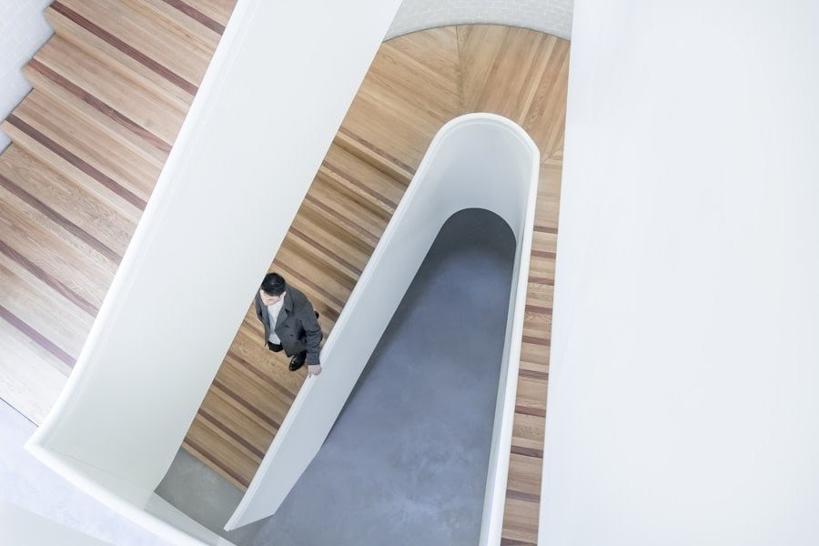 A person ascending a staircase in a modern building with a minimalist design.