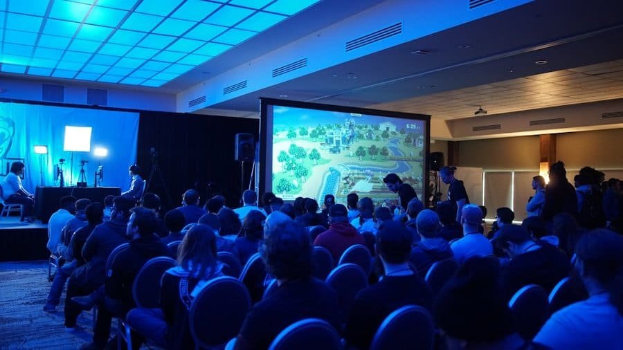 Audience watching a video game tournament at a convention hall.