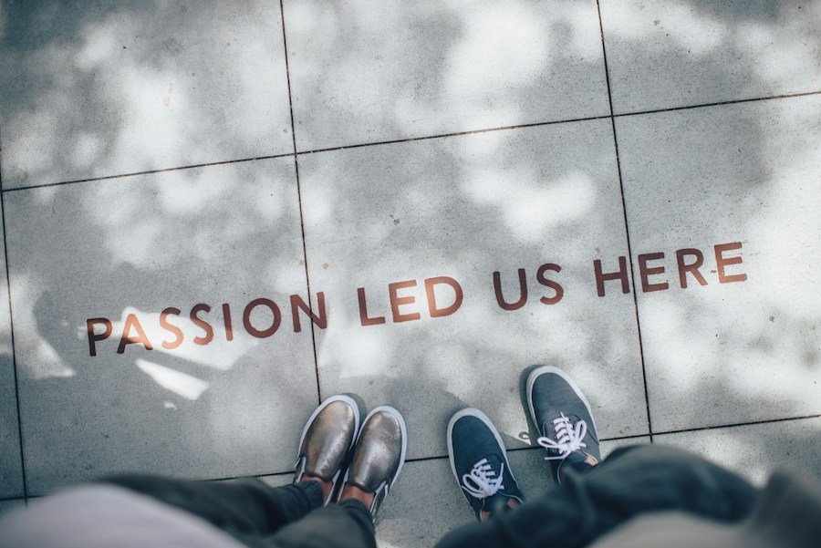 Two people standing over a pavement with the phrase "passion led us here" inscribed on it.