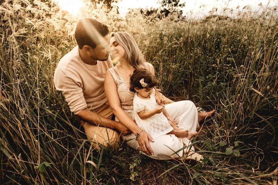 Family enjoying time together in a sunlit field.